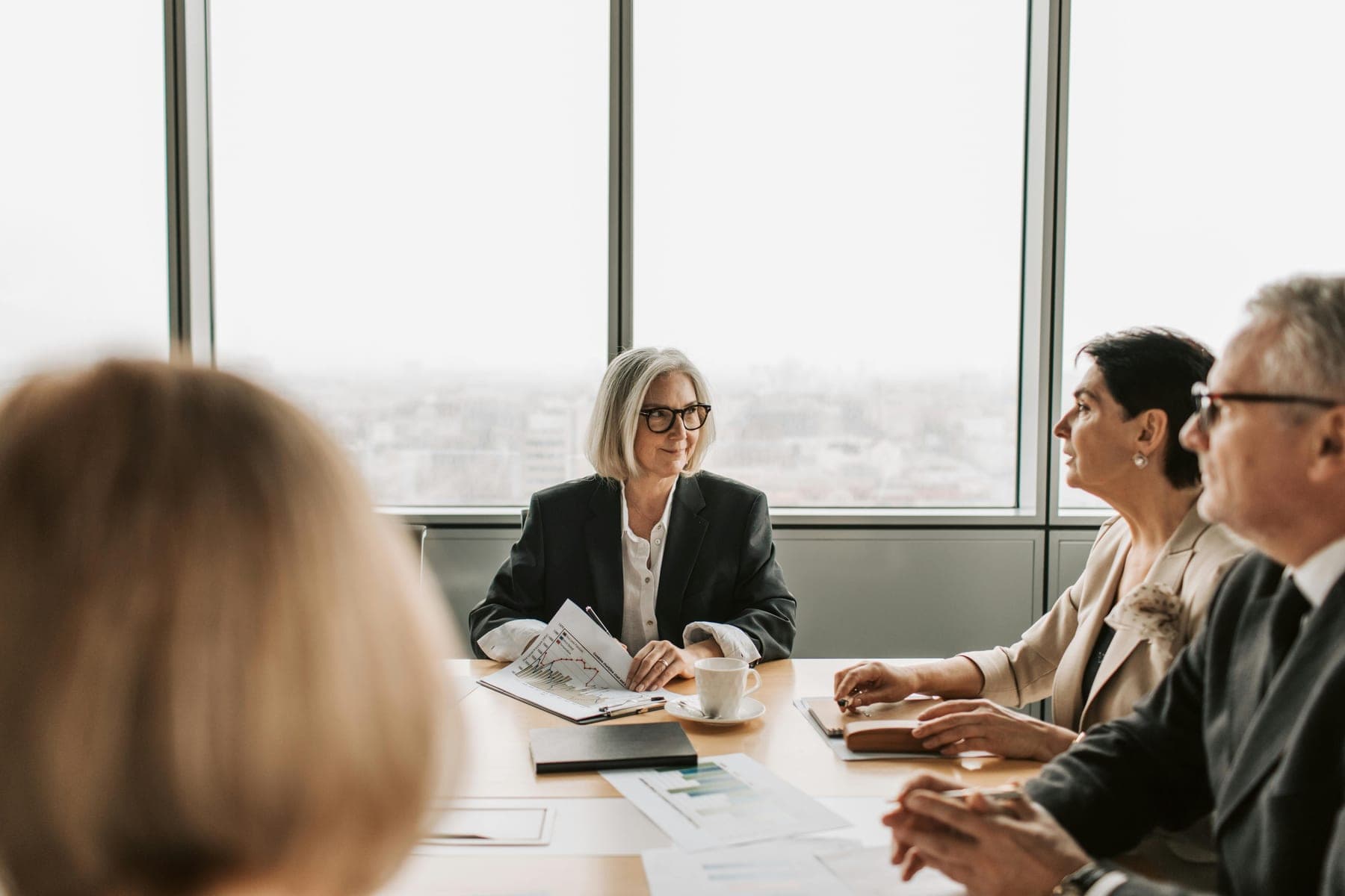 ASE-style boardroom review with principals discussing documents